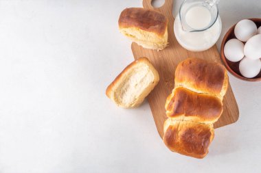 Japanese bread Shokupan, Hokkaido milk bread, or simply milk fluffy buns, on kitchen table, copy space clipart