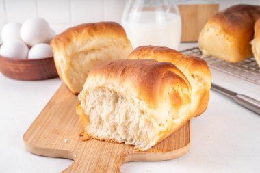 Japanese bread Shokupan, Hokkaido milk bread, or simply milk fluffy buns, on kitchen table, copy space clipart