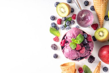 Ev yapımı meyve ve meyveli dondurma, sağlıklı meyve ve yoğurt ile porsiyonlu dondurma taze yaban mersini, ahududu, çilek, böğürtlen, elmalar, mutfak masasında kivi.