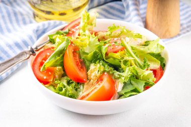 Marul, dilimlenmiş domates, susam tohumu ve zeytinyağlı sade sağlıklı sebze salatası. 