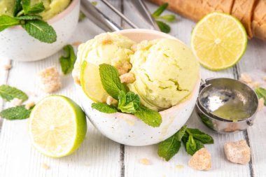 Yaz ferahlatıcı soğuk tatlı, lezzetli aromatik mojito veya limonlu turtalı dondurma, seramik kasede mojito kokteyli aromalı ev yapımı şerbet, taze limon, nane, ahşap zemin üzerinde waffle konileri.