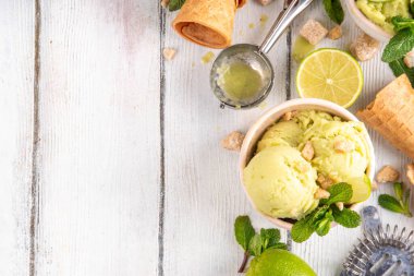 Yaz ferahlatıcı soğuk tatlı, lezzetli aromatik mojito veya limonlu turtalı dondurma, seramik kasede mojito kokteyli aromalı ev yapımı şerbet, taze limon, nane, ahşap zemin üzerinde waffle konileri.
