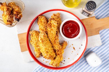 Lezzetli, taze pişmiş tavuk nugget ya da şeritli, altın mısır ekmekli, daha az yağda kızartılmış. Ev yapımı dengeli diyet fast food alternatifi