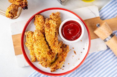 Lezzetli, taze pişmiş tavuk nugget ya da şeritli, altın mısır ekmekli, daha az yağda kızartılmış. Ev yapımı dengeli diyet fast food alternatifi