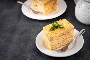 Ev yapımı Napolyon pastası dilimleri, vanilyalı kremalı katmanlı milföy pastası, lezzetli, çatallı servis tabakları, fotokopi alanı.