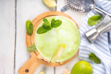 Mojito limonata, alkollü buzlu kokteyl, martini bardağında, yaz ferahlatıcı buzlu içecek, votka, limon suyu ve nane şurubu, bardaklarla dolu beyaz bir masada.