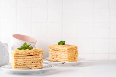 Ev yapımı Napolyon pastası dilimleri, vanilyalı kremalı katmanlı milföy pastası, lezzetli, çatallı servis tabakları, fotokopi alanı.