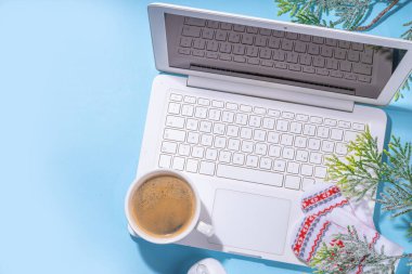 Kış ve Noel ofis çalışma alanı dizüstü bilgisayarı, not defteri, örgü eldivenler, kazak ya da ekose, Noel ağacı dalları, hediye kutusu, iş yerindeki düz konum üzerine dekorasyon üst görünüm alanı