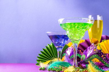 Mardi Gras kokteylleri hazır. Renkli mor, sarı, yeşil martini şampanya Mardi Gras parti barı için şarap bardakları karnaval dekorlu ve Orleans maskeli