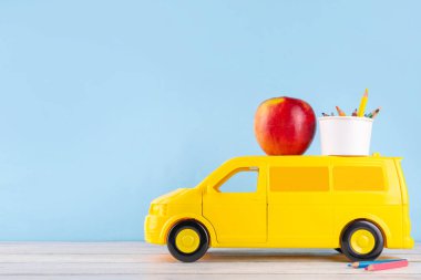 Okul gereçleri ve geleneksel hediyelerle Öğretmenler Haftası arka planı, kalemli, kalemli, defterli, not defterli, okul otobüsü oyuncağı, çocuktan öğretmene tebrik kartı.