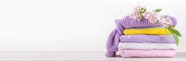 Pastel renkli çiçek desenli bahar giysileri. Bahar indirimi konsepti, indirimli moda mağazası reklamı. Bahar temizliği, çamaşır arka planı