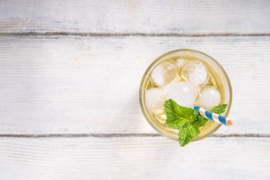 Soğuk vanilyalı soda. Sıcak yaz günleri için, beyaz ahşap masa fotokopisinde bol miktarda ezilmiş buz ve nane aromalı alkolsüz içecek.