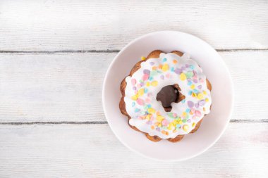 Geleneksel Paskalya pastası şekerleme ve şekerle süslenmiş, şenlikli ruh dekorasyonu ve çiçek buketiyle süslenmiş. Paskalya kutlamaları pastel renkli Paskalya yumurtaları ve tavşan tavşanlarıyla dolu tatil masası.