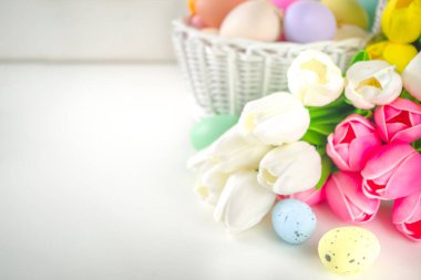Paskalya yumurtaları ve bahar lale çiçekleriyle dolu bir sepet. Bahar Paskalya Bayramı tebrik kartı, metin için davet arkaplan kopyalama alanı