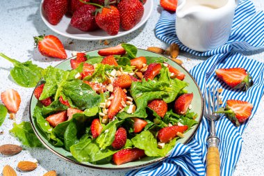 Çilek, ıspanak ve fındık salatası. Sağlıklı diyet yaz salatası, ıspanak yaprakları, doğranmış badem ve organik çilek dilimleri, kopyalama alanı.