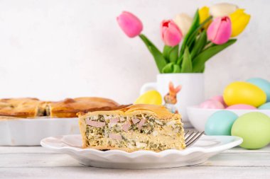 Paskalya Savory Pizza 'sı, geleneksel İtalyan paskalya pastası Rustica' lı jambon, salam, ricotta peyniri, yumurta ve ıspanak, dekoratif masa, kopyalama alanı.