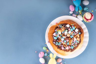 Tatlı Paskalya tatlı pizzası, çikolata soslu, marşmelov ve çikolatalı yumurta, Paskalya bayramı çocukları için atıştırmalık, şenlikli süslemeler, renkli yumurtalar ve tavşan tavşanlı.