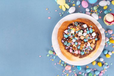 Tatlı Paskalya tatlı pizzası, çikolata soslu, marşmelov ve çikolatalı yumurta, Paskalya bayramı çocukları için atıştırmalık, şenlikli süslemeler, renkli yumurtalar ve tavşan tavşanlı.