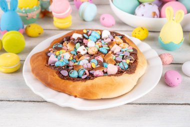 Tatlı Paskalya tatlı pizzası, çikolata soslu, marşmelov ve çikolatalı yumurta, Paskalya bayramı çocukları için atıştırmalık, şenlikli süslemeler, renkli yumurtalar ve tavşan tavşanlı.