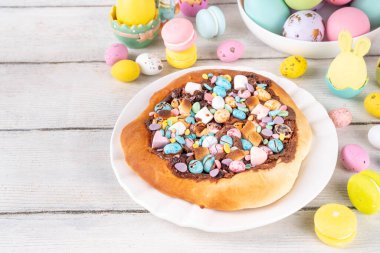 Tatlı Paskalya tatlı pizzası, çikolata soslu, marşmelov ve çikolatalı yumurta, Paskalya bayramı çocukları için atıştırmalık, şenlikli süslemeler, renkli yumurtalar ve tavşan tavşanlı.