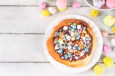 Tatlı Paskalya tatlı pizzası, çikolata soslu, marşmelov ve çikolatalı yumurta, Paskalya bayramı çocukları için atıştırmalık, şenlikli süslemeler, renkli yumurtalar ve tavşan tavşanlı.