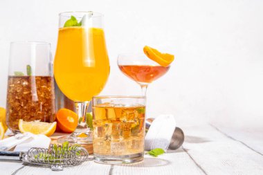 Modaya uygun çay seti yeşil, oolong, siyah, çay ve diğer çay karışımlarından esinlenilmiştir. Soda, şerbetli soğuk yaz içecekleri, limon, kireç ve nane, güneşli beyaz ahşap arka plan.