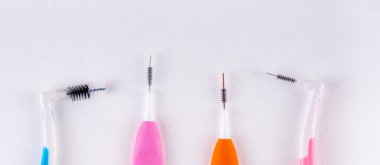 Farklı diş fırçaları, diş ipleri ve mavi arka planda diş fırçaları. Diş ve ortodontik bakım araçları, üst görünüm kopyalama alanı