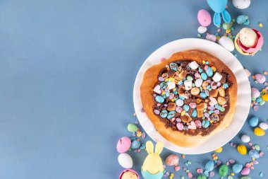 Tatlı Paskalya tatlı pizzası, çikolata soslu, marşmelov ve çikolatalı yumurta, Paskalya bayramı çocukları için atıştırmalık, şenlikli süslemeler, renkli yumurtalar ve tavşan tavşanlı.