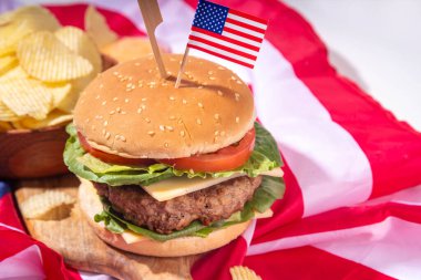 Lezzetli çizburger, patates kızartması ve soslu vatansever Amerikan bayrağı. 4 Temmuz, Bağımsızlık Günü piknik yemeği, ABD temalı bbq hamburger fotokopi alanı