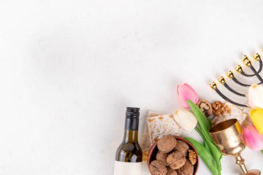 Hamursuz Bayramı geçmişi. Geleneksel Yahudi ekmek matzası, kırmızı koşer şarabı, ceviz, bahar güzel çiçekleri. Yahudi Paskalya Pesah bahar tatili arka plan kopya alanı