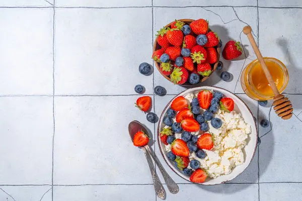 Çilekli süzme peynir. Bir kase süzme peynirli çilek, yabanmersini, yüksek proteinli yaz sağlıklı kahvaltı veya öğle yemeği, kopyalama alanı