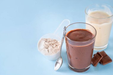 Hızlı ve basit protein pudingi. Sağlıklı yaz soğuk tatlısı. Üç bardak vanilyalı, çikolatalı ve çilekli puding, çikolata dilimleri, taze çilek, yabanmersini, protein tozu