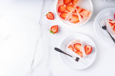 Japon yağmur damlası keki, ya da Mizu Shingen Mochi, berrak jöle tatlısı, kristal berrak su benzeri lezzetli, çilek dilimli tart, tabaklar üzerine porsiyonlu, beyaz mermer arka plan fotokopi alanı