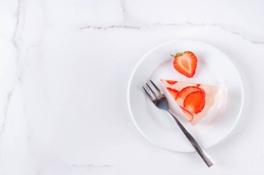 Japon yağmur damlası keki, ya da Mizu Shingen Mochi, berrak jöle tatlısı, kristal berrak su benzeri lezzetli, çilek dilimli tart, tabaklar üzerine porsiyonlu, beyaz mermer arka plan fotokopi alanı