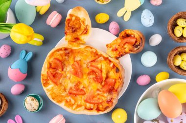 Çocuklar için şirin Paskalya pizzası brunch ya da parti, tavşanlı pizza ve paskalya yumurtaları, sebzeli, peynirli ve domates soslu, 