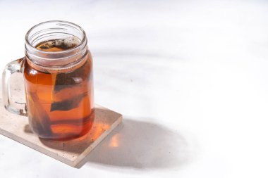 Mason kavanozunda güneş çayı, modaya uygun soğuk, tatlı güneş çayı ahşap masada içki.