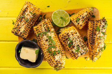 Vejetaryen bbq yemeği, ızgara tuzlanmış baharatlı mısır, tereyağı ve yeşillikler.