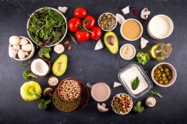 Bitki bazlı keto gıda arka planı, düşük karbonhidratlı vejetaryen keto diyet malzemeleri, sağlıklı vejetaryen yağ ve protein kaynağı. Çeşit çeşit yeşil sebzeler, fındık, baklagiller, yağ, hindistan cevizi, fıstık, fıstık ezmesi