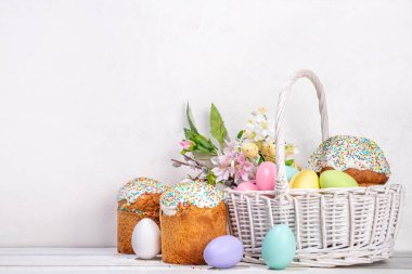 Paskalya pastalı geleneksel Paskalya sepeti rengarenk pastel yumurtalar, tavşan tavşanlar ve bahar çiçekleri. Paskalya kutlaması için hazırlık, tebrik kartı, davetiye, Paskalya indirimi