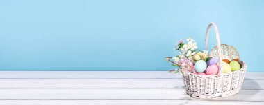 Paskalya pastalı geleneksel Paskalya sepeti rengarenk pastel yumurtalar, tavşan tavşanlar ve bahar çiçekleri. Paskalya kutlaması için hazırlık, tebrik kartı, davetiye, Paskalya indirimi