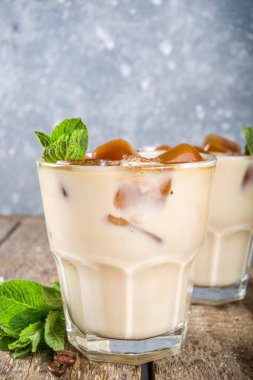 Soğuk yaz kahvesi, latte, frappe, frappuccino. Buzlu kahve, dondurulmuş kahve, buzlu, sütlü ya da sütsüz, naneli. Ahşap arkaplan kopyalama alanı