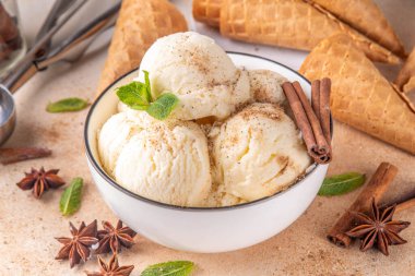 Hindistan 'da soğuk yaz Garam Masala Gelato tatlısı, Hindistan' da üç baharatlı dondurma, beyaz seramik kasede, nane yaprakları, baharatlar ve kremalı dondurma külahları.
