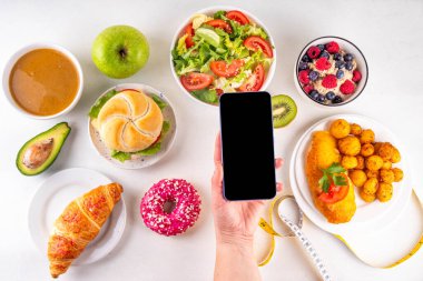 Sağlıklı ve sağlıksız yiyecek tabakları, meyveler, sebzeler, tatlı, donut ve hamburger içeren kalori hesabı diyeti. Kalori sayımı, gıda kontrol konsepti