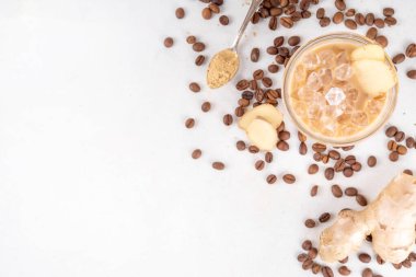 Soğuk zencefilli kahve fincanı. Beyaz zemin üzerinde zencefil tozu ve zencefil kökü olan kremalı buzlu içecek. Sağlıklı sıcak içecek. alternatif tıp, çare 