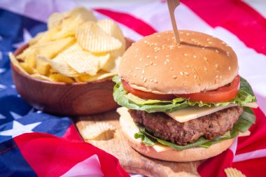 Lezzetli çizburger, patates kızartması ve soslu vatansever Amerikan bayrağı. 4 Temmuz, Bağımsızlık Günü piknik yemeği, ABD temalı bbq hamburger fotokopi alanı