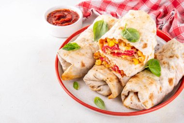 Ev yapımı fırında pizza, pizza stili quesadilla dürümleri pepperoni ya da salam, domates, peynir ve mısır, mutfak masasında sıcak domates sosu, fotokopi alanı.