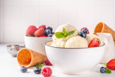 Vanilyalı dondurma kasesi ve taze böğürtlen. Klasik vanilyalı dondurma, çilek, ahududu, böğürtlen, böğürtlen ve kremalı dondurma.
