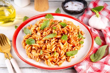 Bolonez soslu Fusilli makarna, kıyma, mantar, domates ve fesleğen. Geleneksel İtalyan yemek tabağı, masada servis edilen baharatlar.