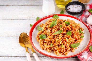 Bolonez soslu Fusilli makarna, kıyma, mantar, domates ve fesleğen. Geleneksel İtalyan yemek tabağı, masada servis edilen baharatlar.