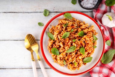 Bolonez soslu Fusilli makarna, kıyma, mantar, domates ve fesleğen. Geleneksel İtalyan yemek tabağı, masada servis edilen baharatlar.